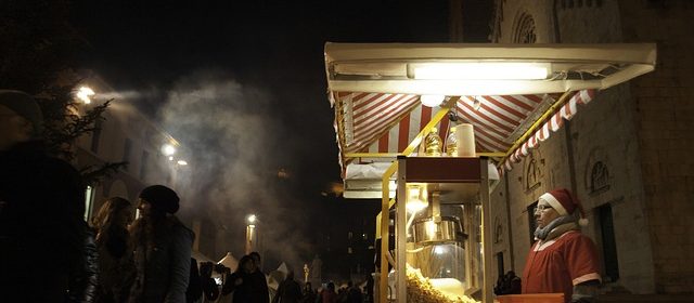 En jultomte står i ett popcornstånd.