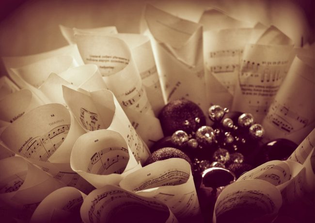 Hoprullade notblad på högkant ställda kring en grupp julgranskulor.