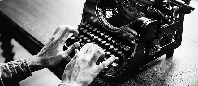 Händer skriver på en skrivmaskin.