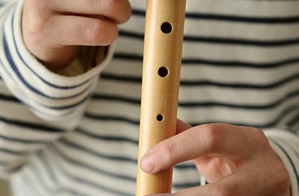En person spelar på en blockflöjt.