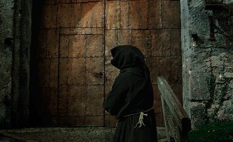 Munk utanför medeltida port.