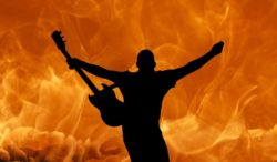 Person med elgitarr framför eld